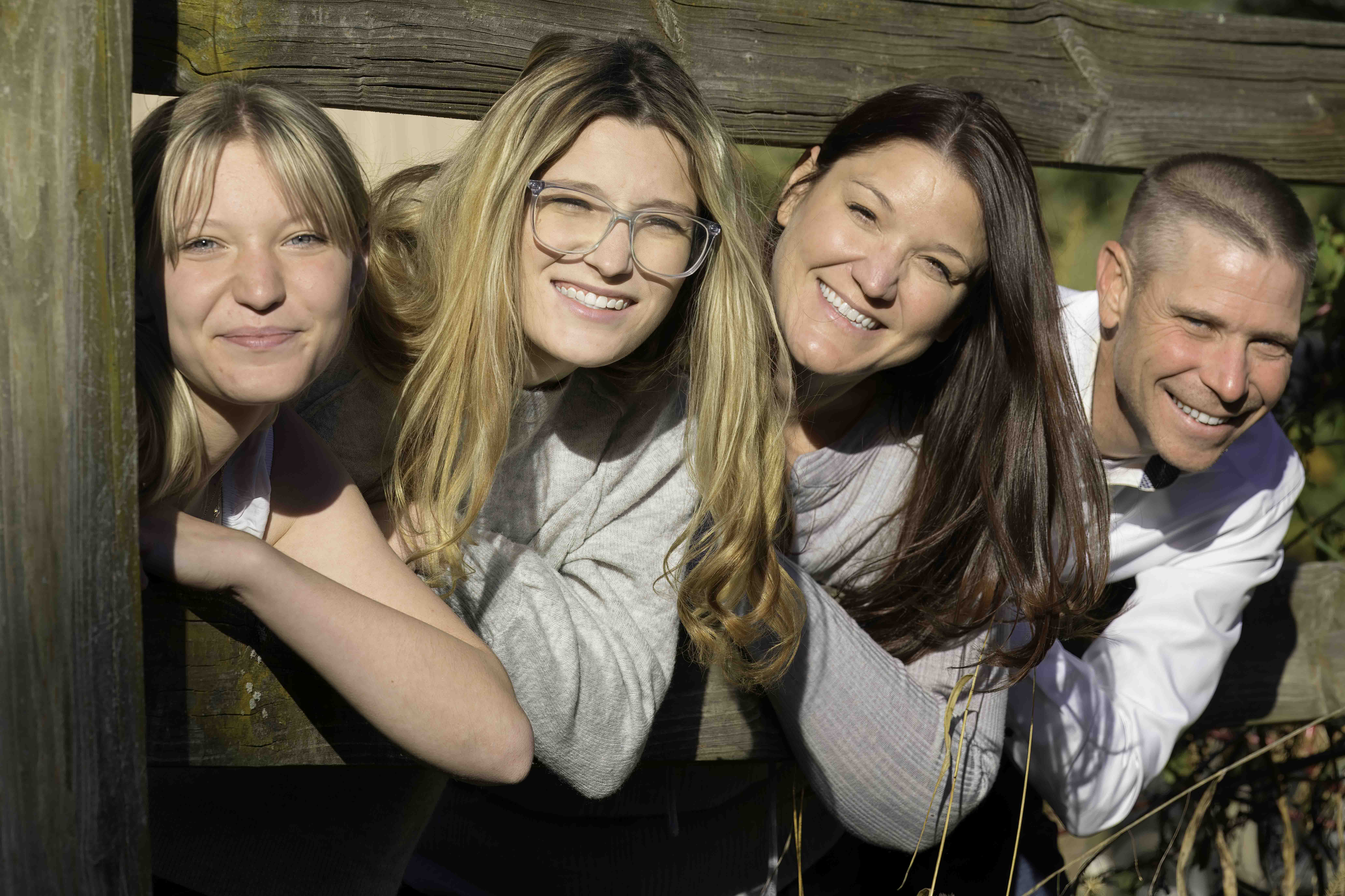 This family photo turned into fun when they peaked out from under a fence